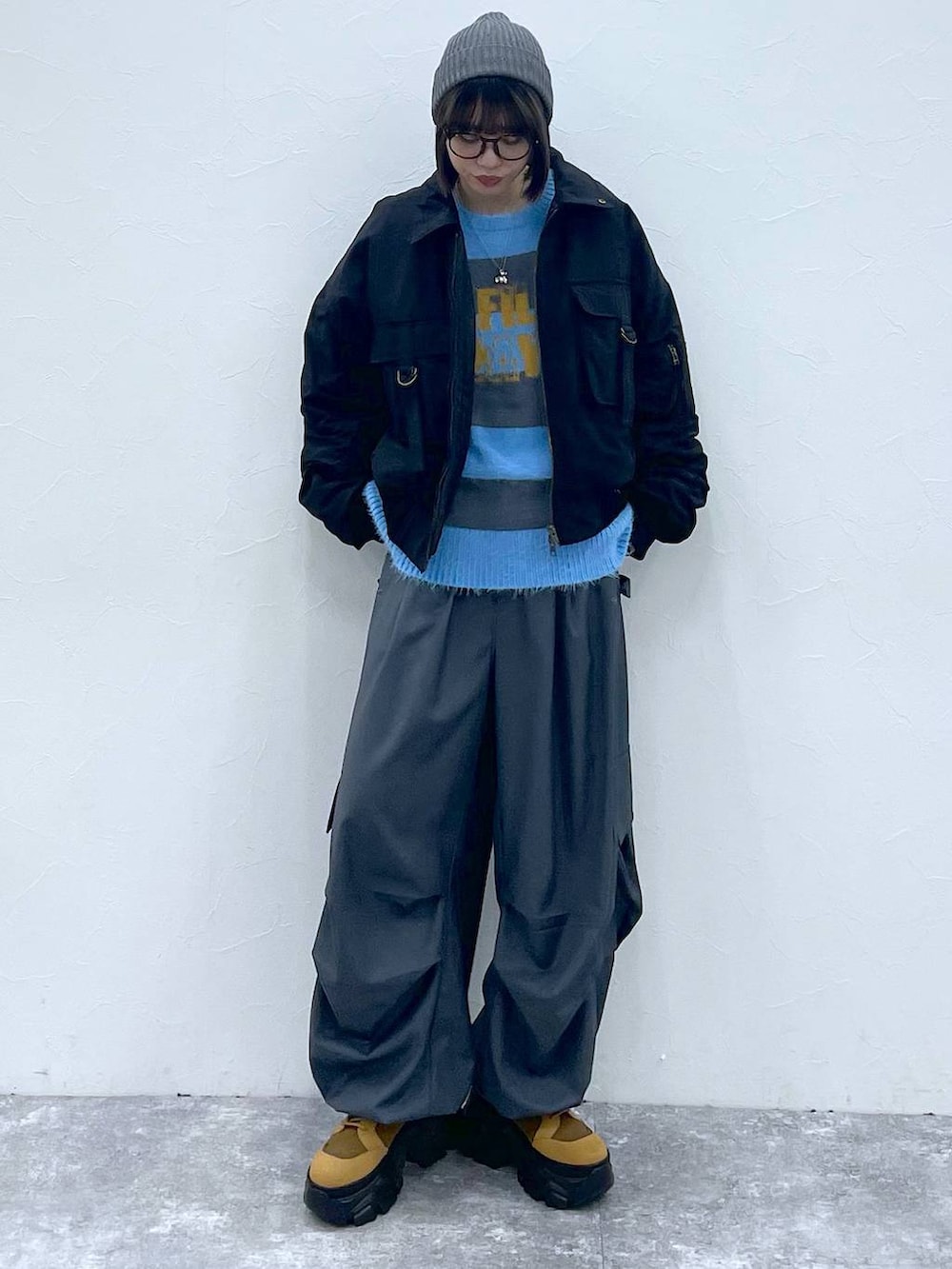 ブラウン系のブーツ、ブラック系のブルゾン、グレー系のカーゴパンツを着用したレディースの秋コーディネートの10枚目の写真