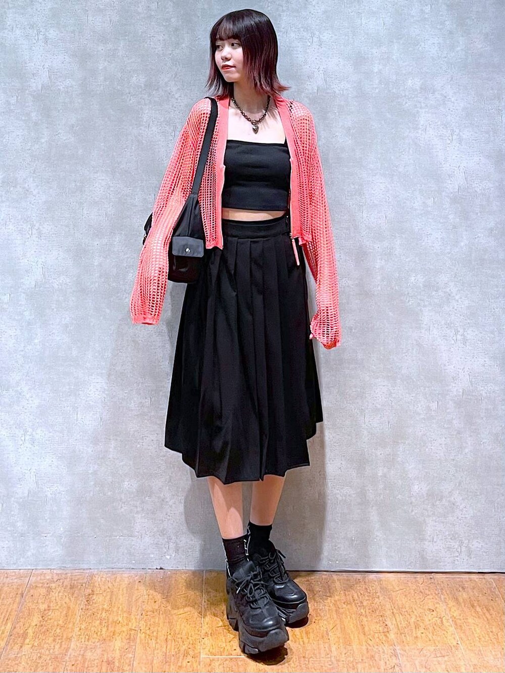 ブラック系のショルダーバッグ、ピンク系のカーディガン/ボレロ、ブラック系のキャミソールを着用したレディースの春コーディネートの2枚目の写真