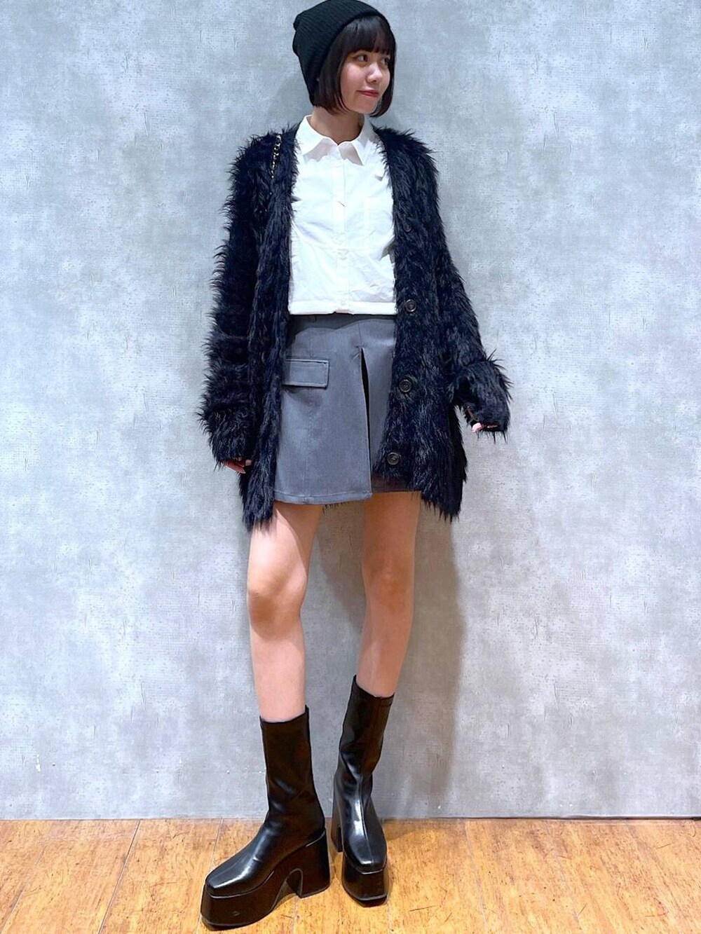 ブラック系のカーディガン/ボレロ、ブラック系のブーツ、ブラック系のショルダーバッグを着用したレディースの冬コーディネートの6枚目の写真