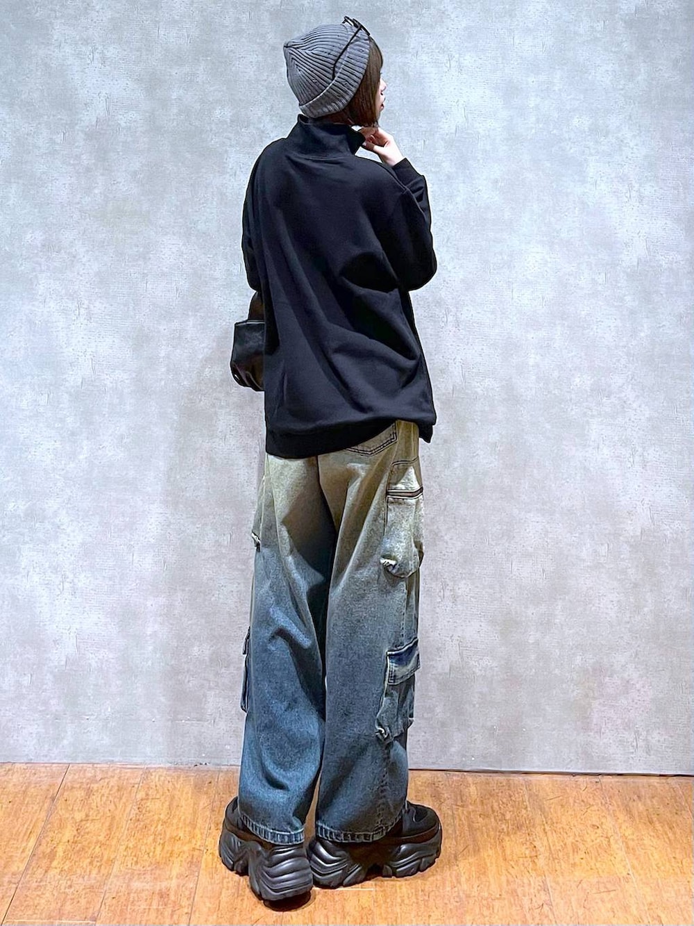 ブラック系のスニーカー、ブルー系のデニムパンツ、ブラック系のハンドバッグを着用したレディースの秋コーディネートの3枚目の写真