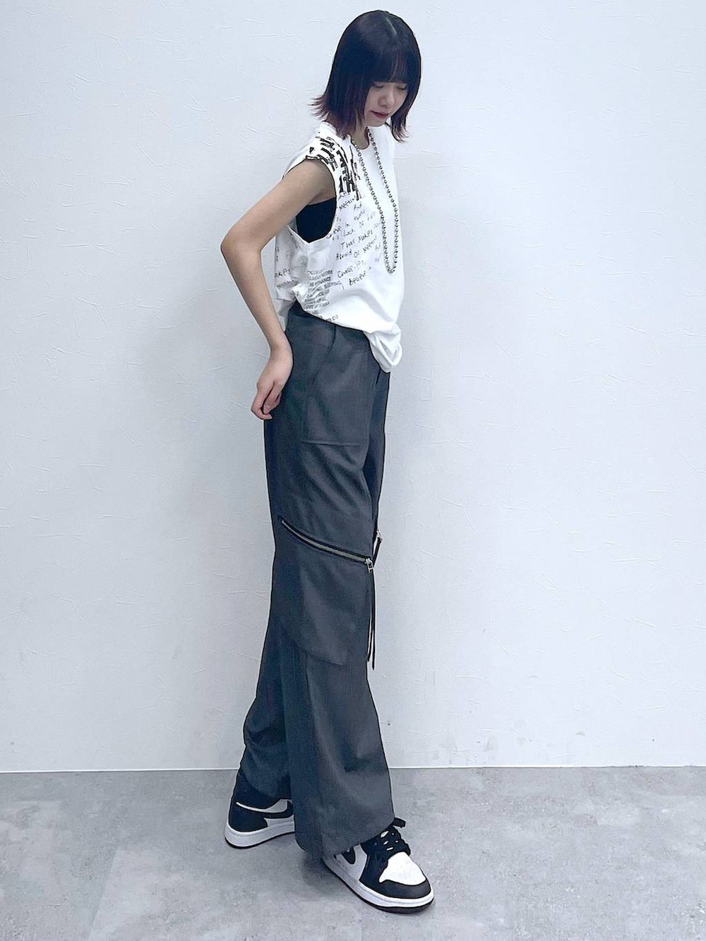 グレー系のスラックス、ホワイト系のTシャツ/カットソー、シルバー系のネックレスを着用したレディースの夏コーディネートの5枚目の写真