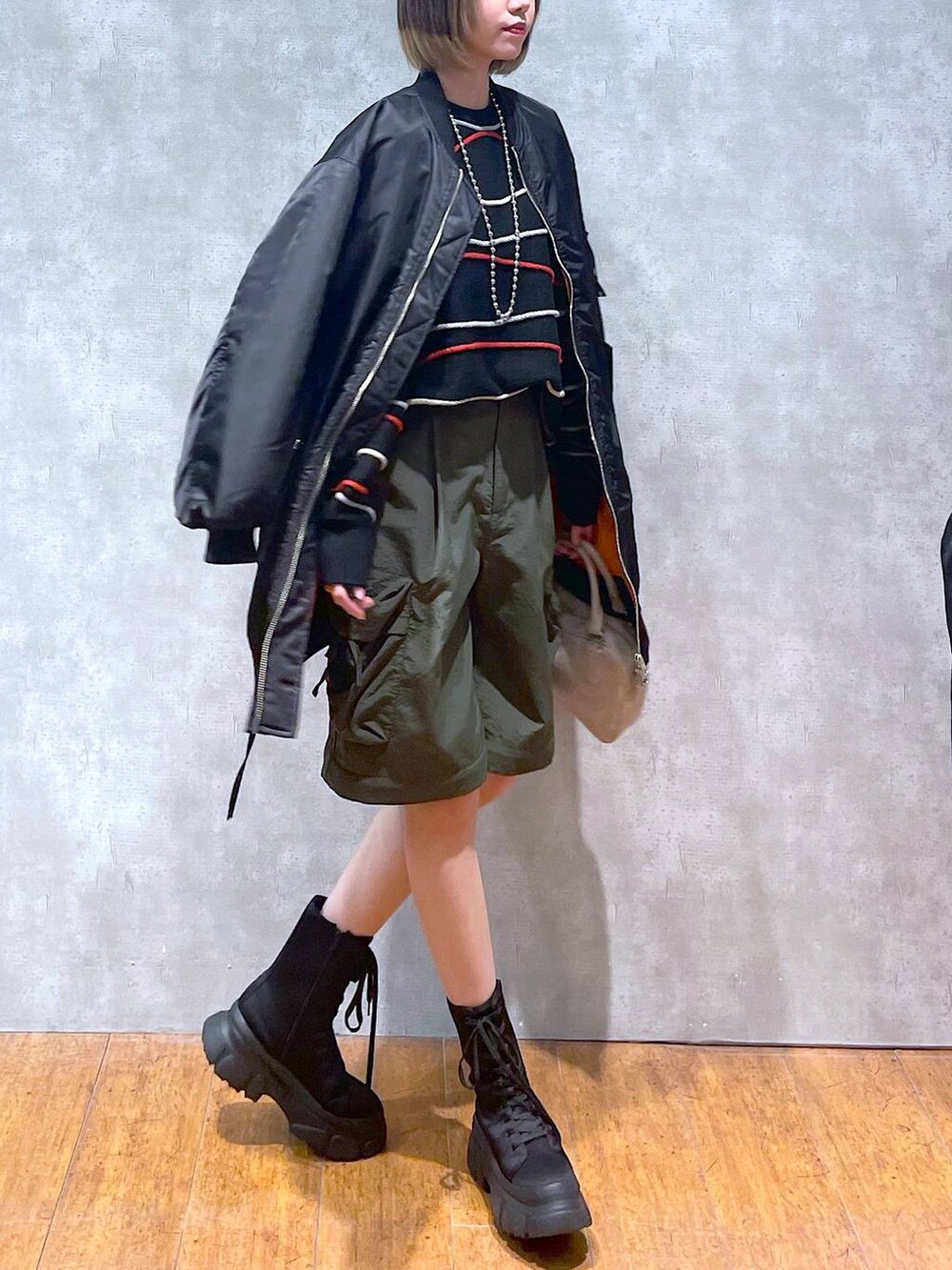 グリーン系のカーゴパンツ、ブラック系のMA-1、ブラック系のニット/セーターを着用したレディースの冬コーディネートの7枚目の写真