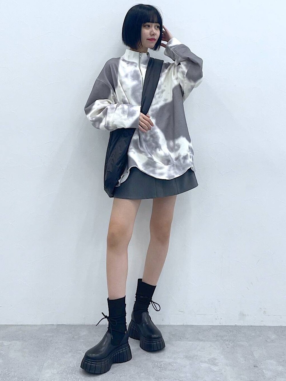 ブラック系のトートバッグ、ブラック系のブーツ、ホワイト系のTシャツ/カットソーを着用したレディースの冬コーディネートの5枚目の写真