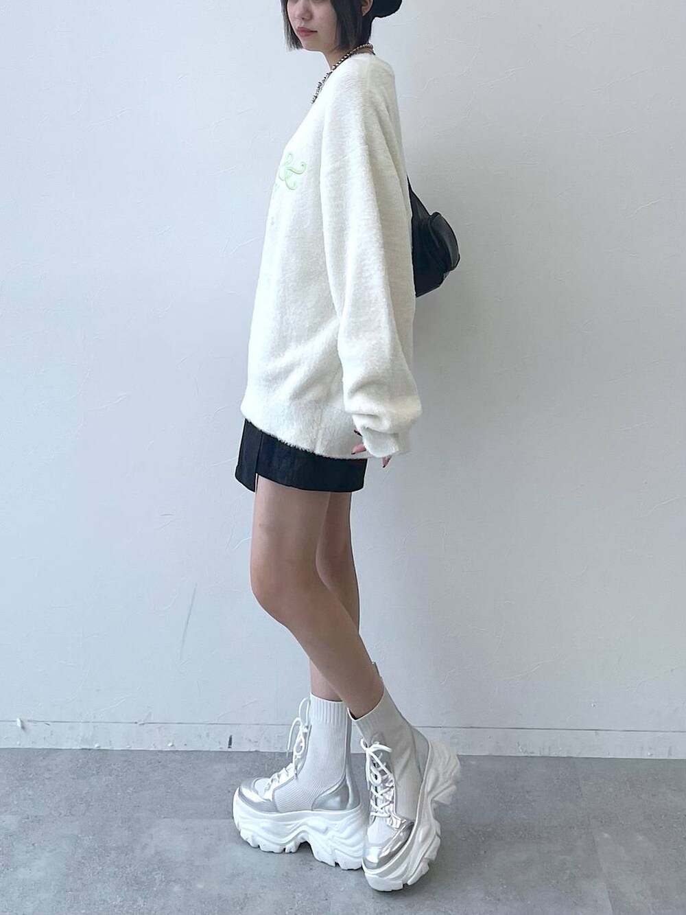 ホワイト系のブーツ、ブラック系のショルダーバッグ、ホワイト系のニット/セーターを着用したレディースの秋コーディネートの3枚目の写真