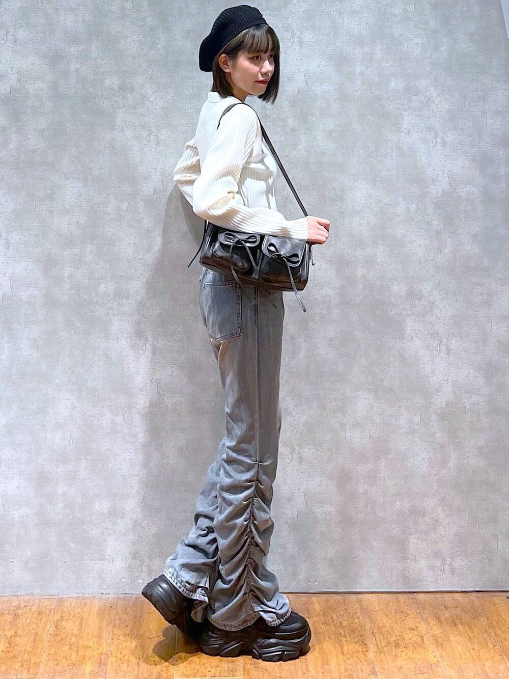 ブラック系のスニーカー、ブラック系のショルダーバッグ、ブラック系のキャミソールを着用したレディースの秋コーディネートの4枚目の写真