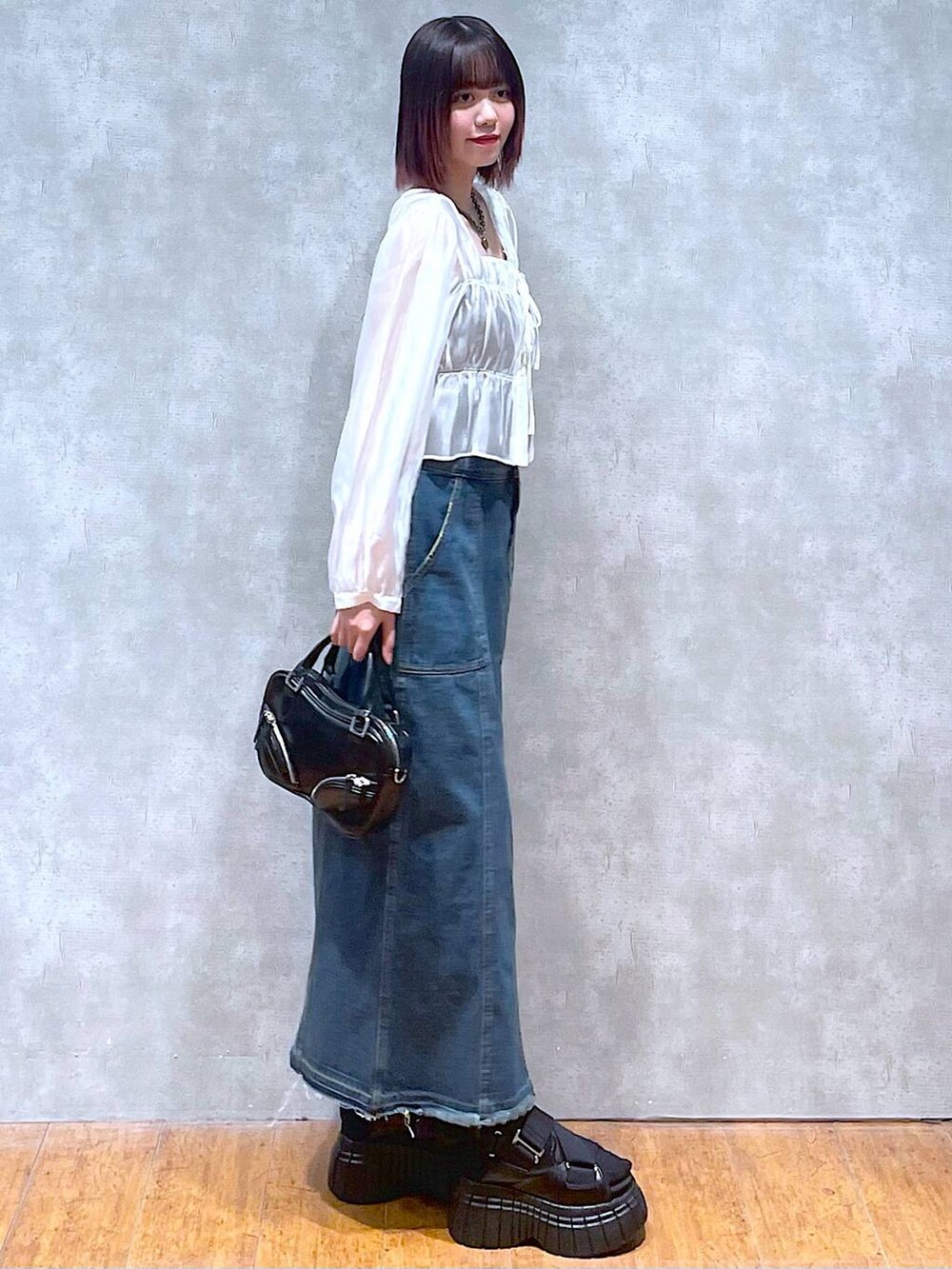 ブラック系のスニーカー、ホワイト系のシャツ/ブラウス、ブラック系のキャミソールを着用したレディースの春コーディネートの3枚目の写真