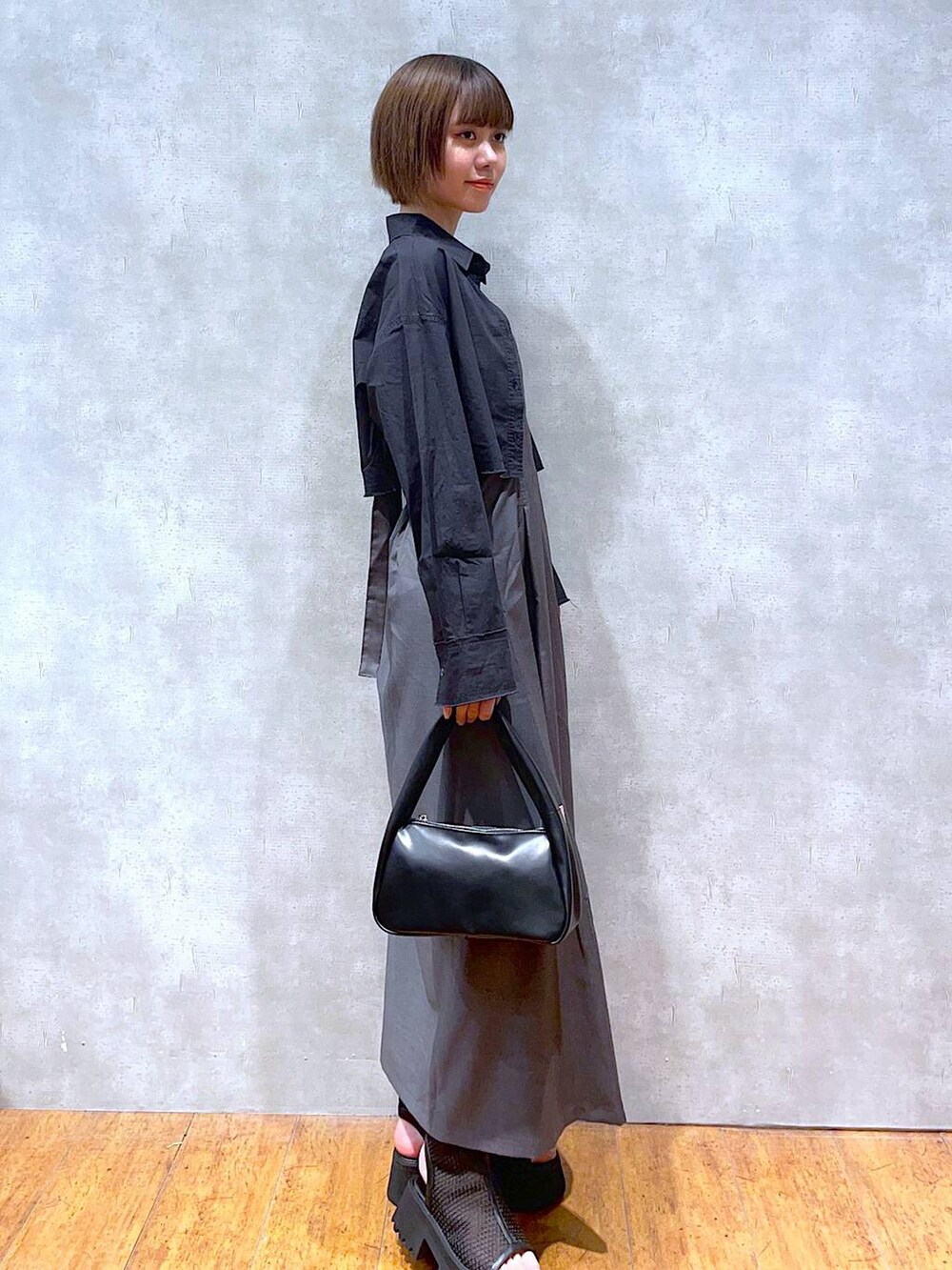 ブラック系のハンドバッグ、ブラック系のサンダル、ブラック系のシャツ/ブラウスを着用したレディースの夏コーディネートの4枚目の写真