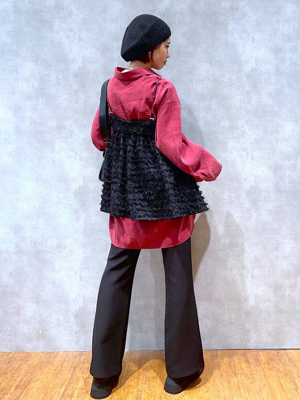 ブラック系のブーツ、ブラック系のスラックス、ブラック系のショルダーバッグを着用したレディースの秋コーディネートの3枚目の写真