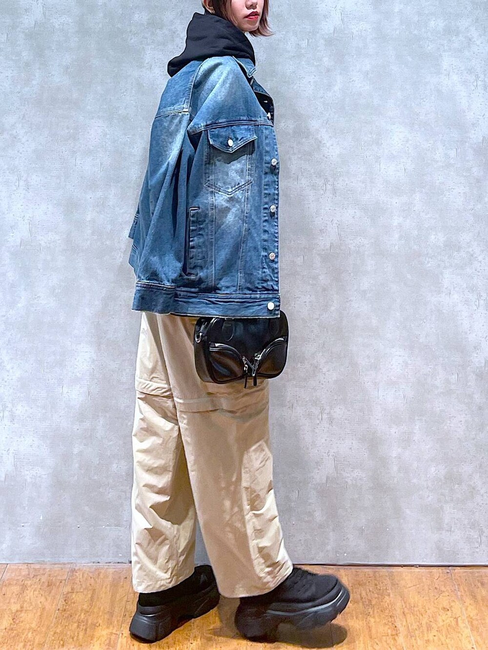 ブルー系のデニムジャケット、ベージュ系のカーゴパンツ、ブラック系のボストンバッグを着用したレディースの春コーディネートの3枚目の写真