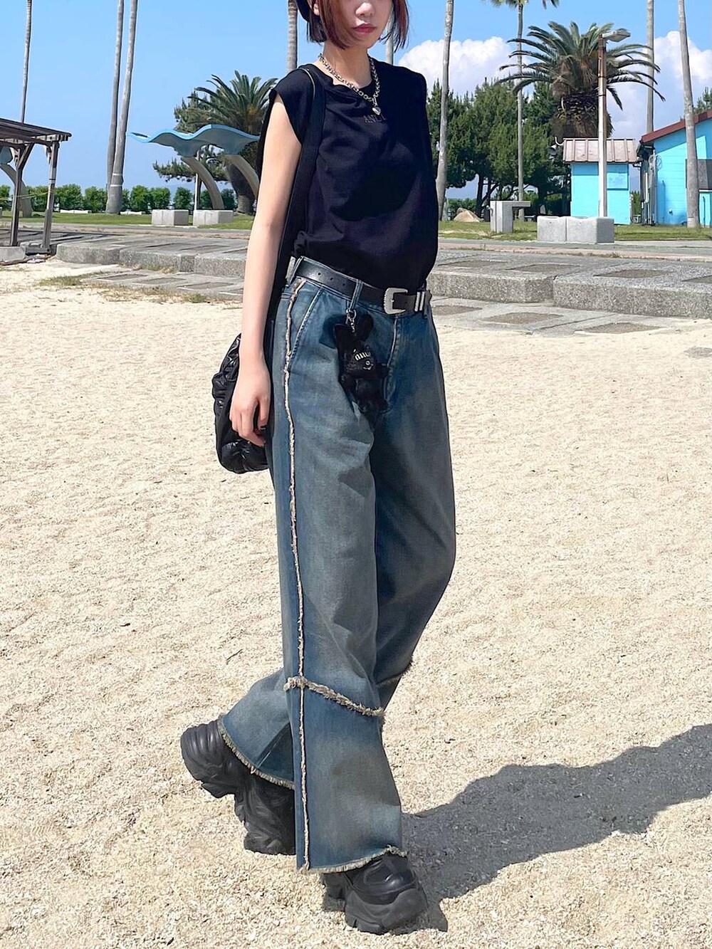 ブラック系のショルダーバッグ、ブラック系のスニーカー、オレンジ系のデニムパンツを着用したレディースの夏コーディネートの8枚目の写真