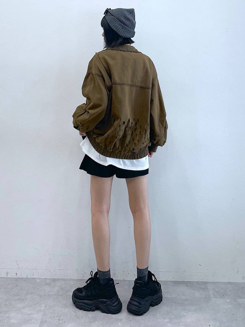 ブラック系のスニーカー、ブラック系のその他パンツ、ブラウン系のデニムジャケットを着用したレディースの夏コーディネートの6枚目の写真
