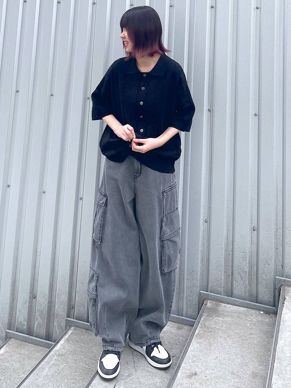 ブラック系のニット/セーター、ブラック系のデニムパンツ、ブラック系のベルトを着用したレディースの春コーディネートの6枚目の写真