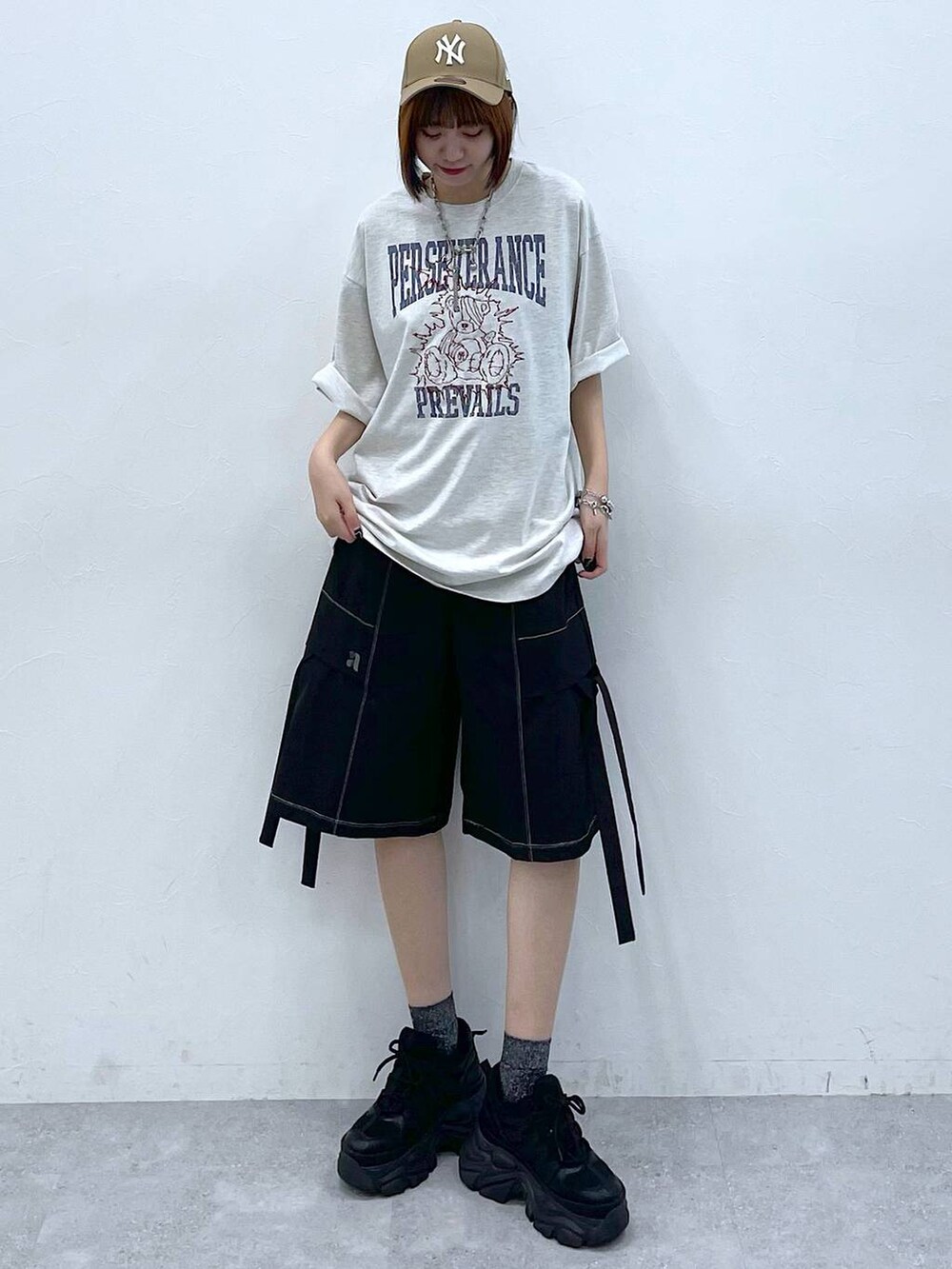 ブラック系のスニーカー、ベージュ系のTシャツ/カットソー、ブラック系のカーゴパンツを着用したレディースの夏コーディネートの4枚目の写真