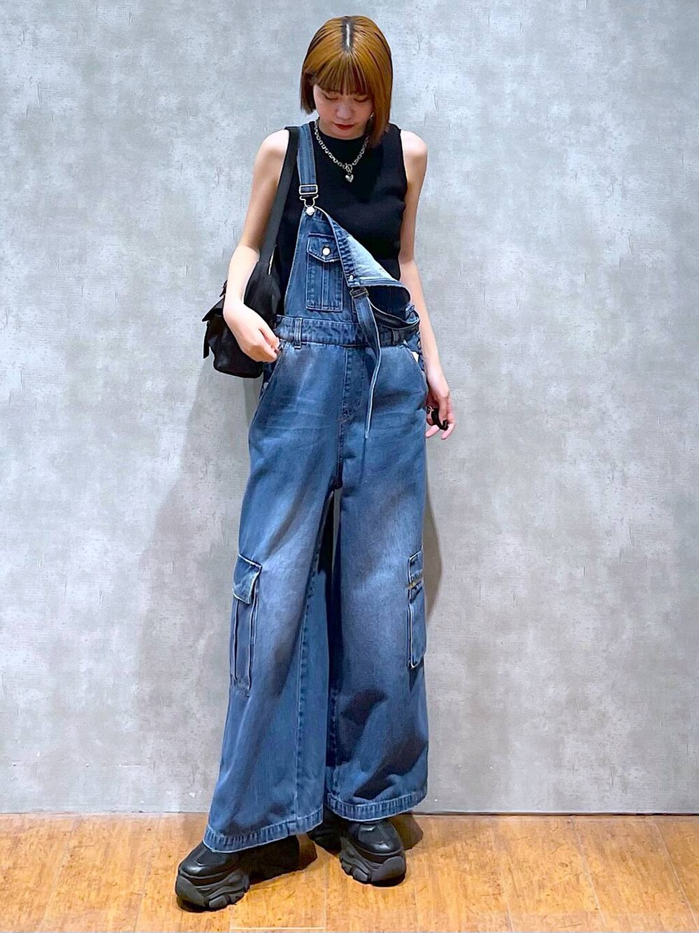 ブラック系のショルダーバッグ、ブラック系のスニーカー、ブラック系のタンクトップを着用したレディースの夏コーディネートの6枚目の写真