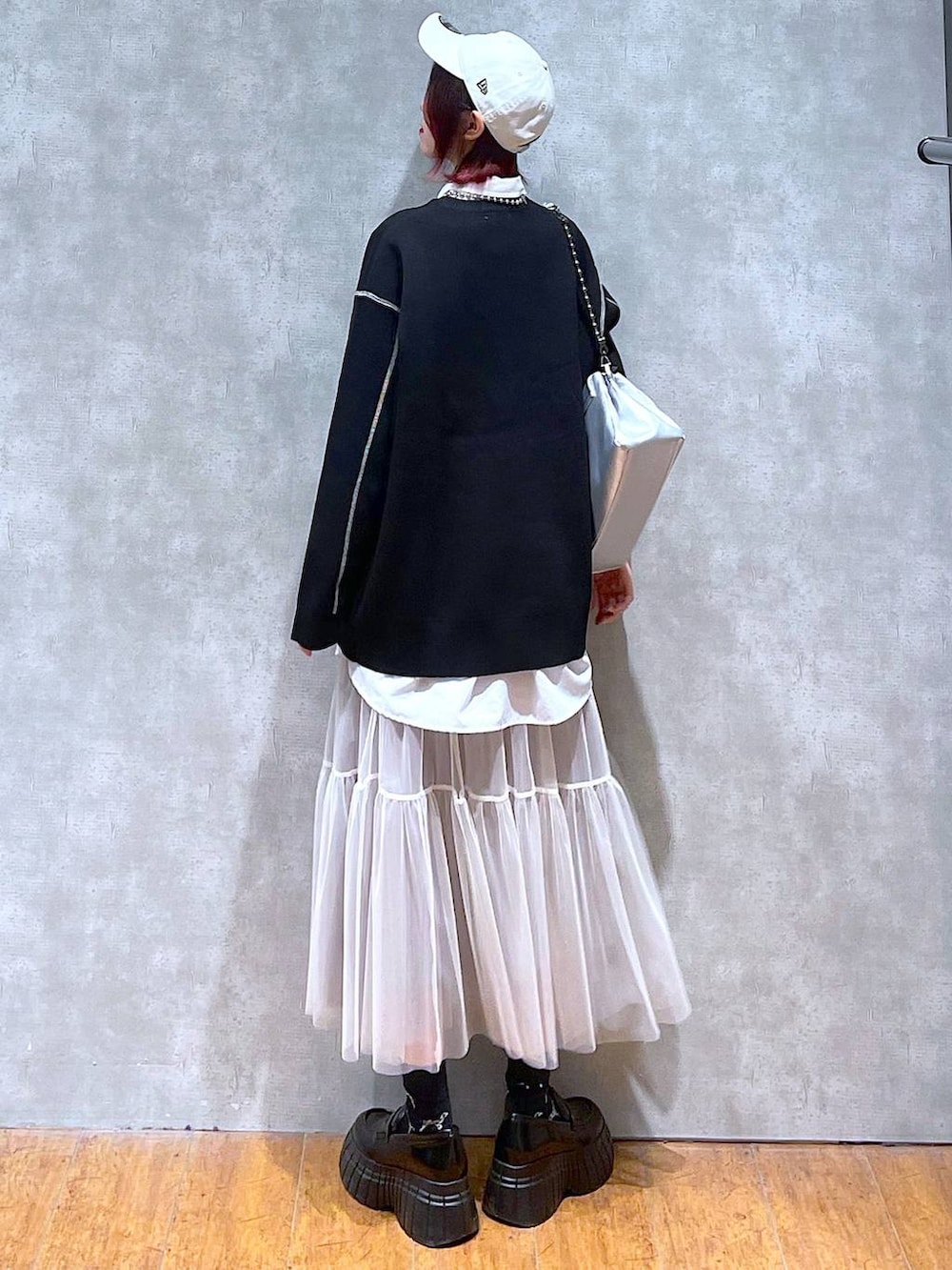 シルバー系のショルダーバッグ、ホワイト系のシャツ/ブラウス、ブラック系のニット/セーターを着用したレディースの春コーディネートの5枚目の写真