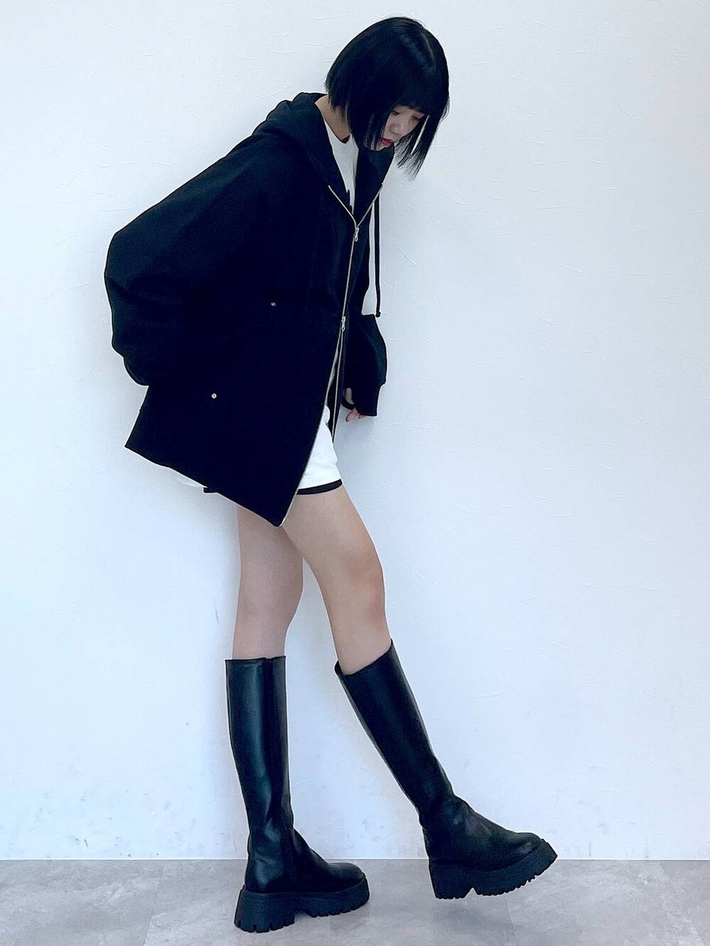 ブラック系のパーカー、ブラック系のブーツ、ブラック系のその他パンツを着用したレディースの冬コーディネートの2枚目の写真