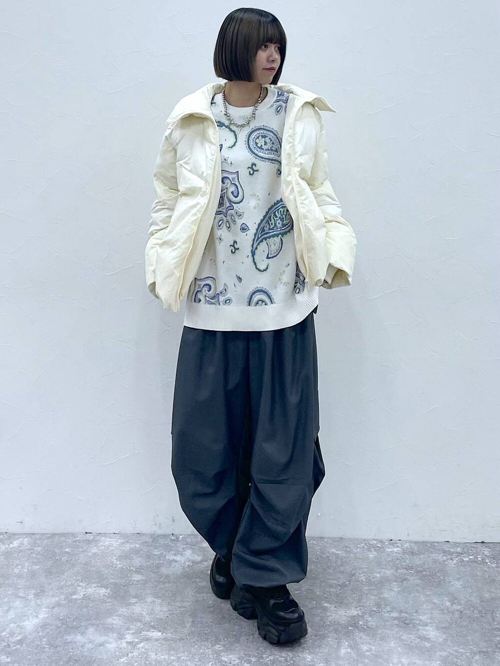 ブラック系のスニーカー、グレー系のカーゴパンツ、ホワイト系のブルゾンを着用したレディースの秋コーディネートの5枚目の写真