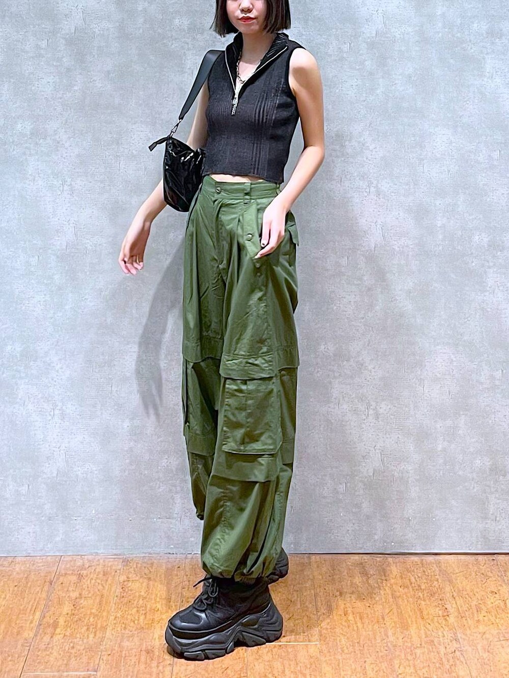 ブラック系のスニーカー、ブラック系のニット/セーター、グリーン系のその他パンツを着用したレディースの夏コーディネートの6枚目の写真