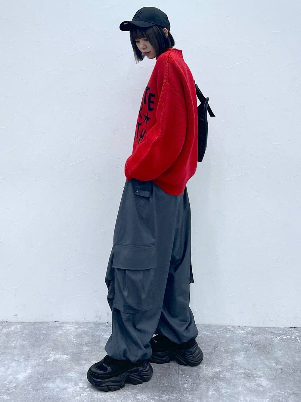 ブラック系のショルダーバッグ、ブラック系のスニーカー、グレー系のカーゴパンツを着用したレディースの秋コーディネートの5枚目の写真