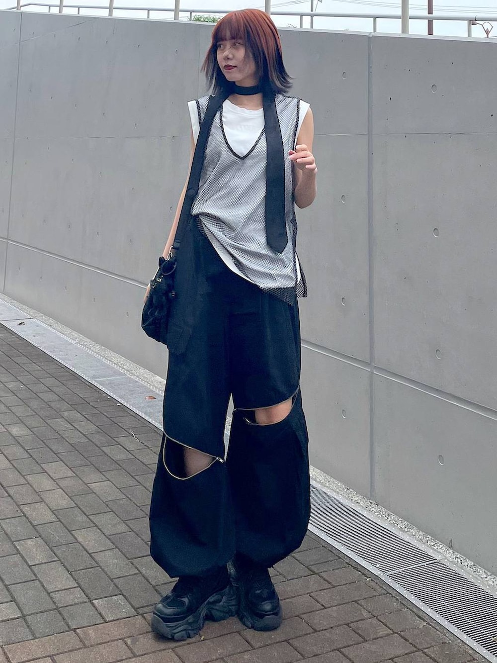 ブラック系のショルダーバッグ、ブラック系のスニーカー、ブラック系のネクタイを着用したレディースの春コーディネートの2枚目の写真