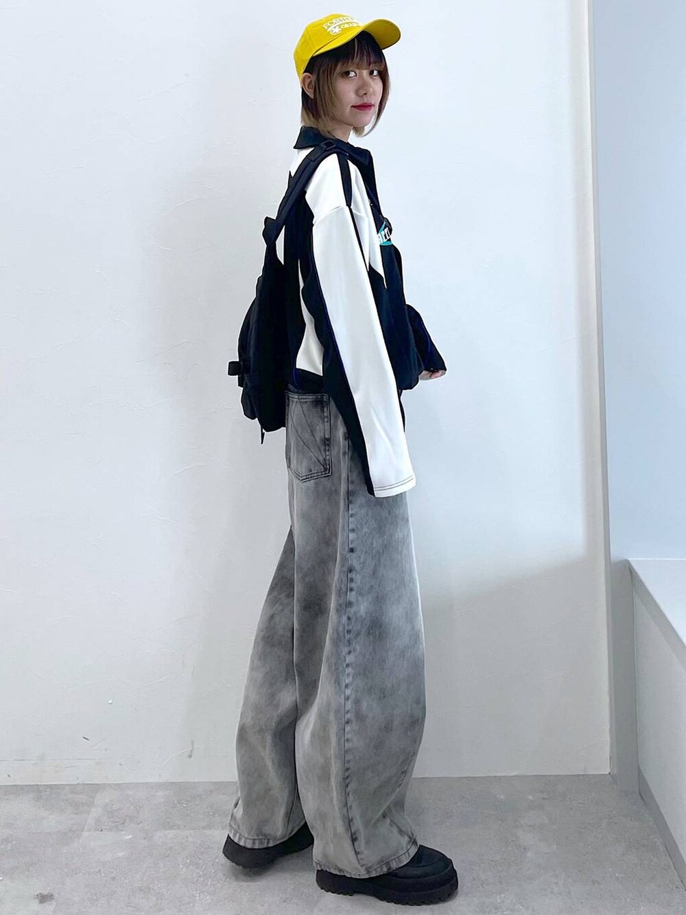 ブラック系のデニムパンツ、ブラック系のボディバッグ/ウエストポーチ、ブラック系のブーツを着用したレディースの冬コーディネートの5枚目の写真