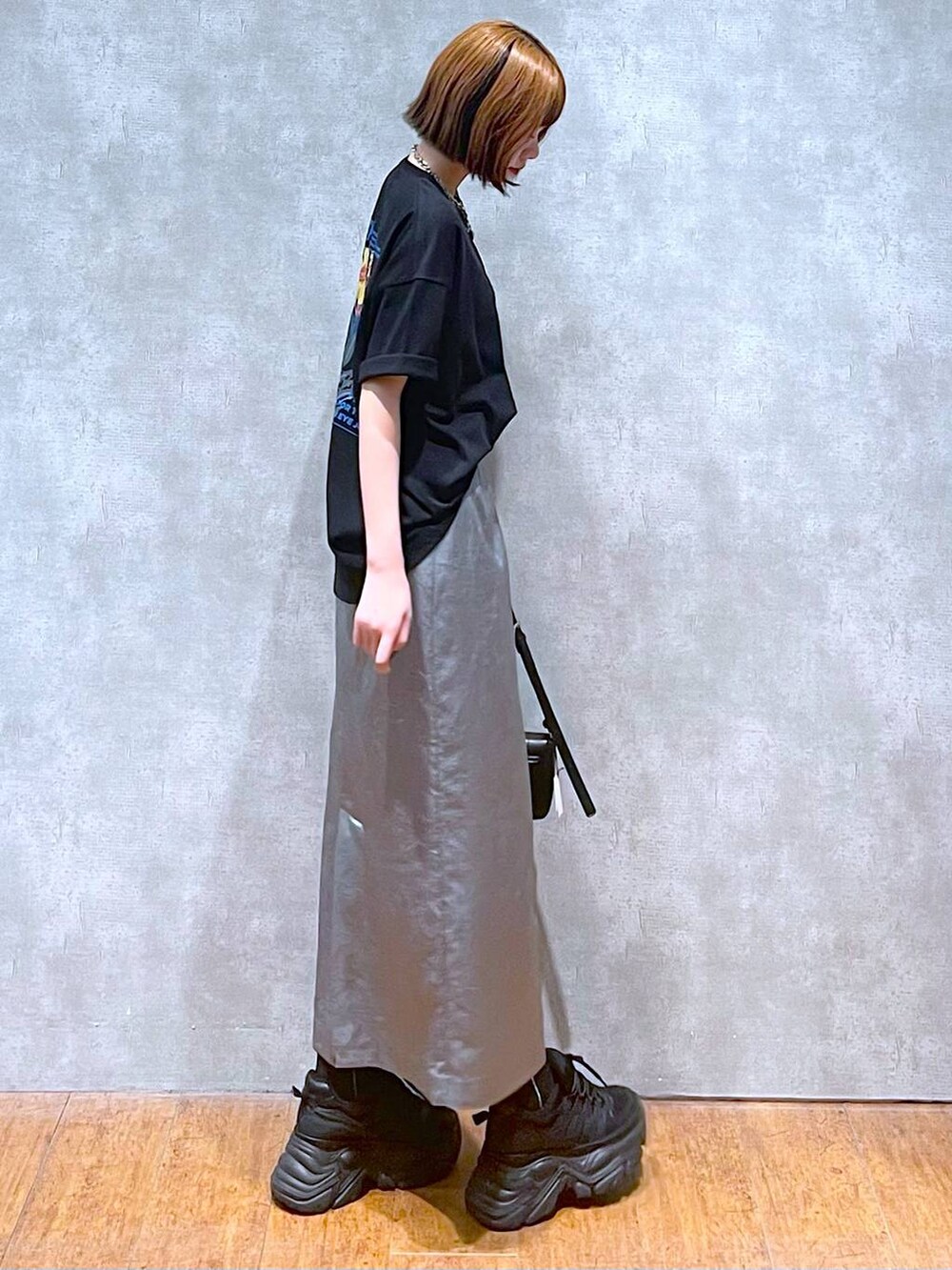 ブラック系のスニーカー、ブラック系のハンドバッグ、ブラック系のTシャツ/カットソーを着用したレディースの夏コーディネートの3枚目の写真