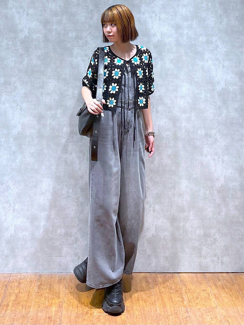 ブラック系のスニーカー、ブラック系のサロペット/オーバーオール、ブラック系のニット/セーターを着用したレディースの夏コーディネートの4枚目の写真