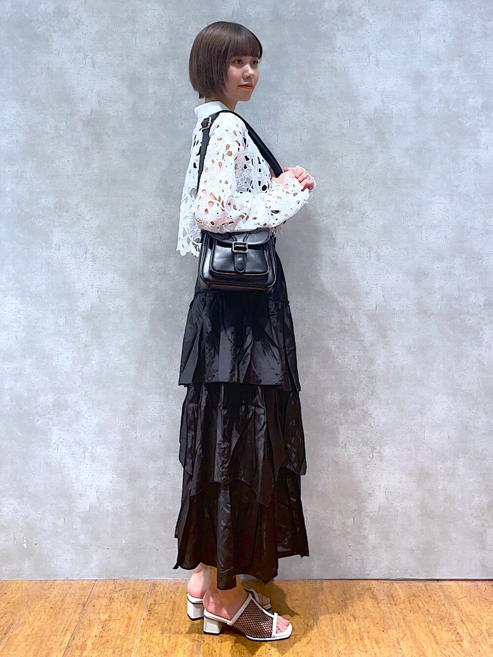 ホワイト系のカーディガン/ボレロ、ブラック系のスカート、ブラック系のショルダーバッグを着用したレディースの夏コーディネートの2枚目の写真