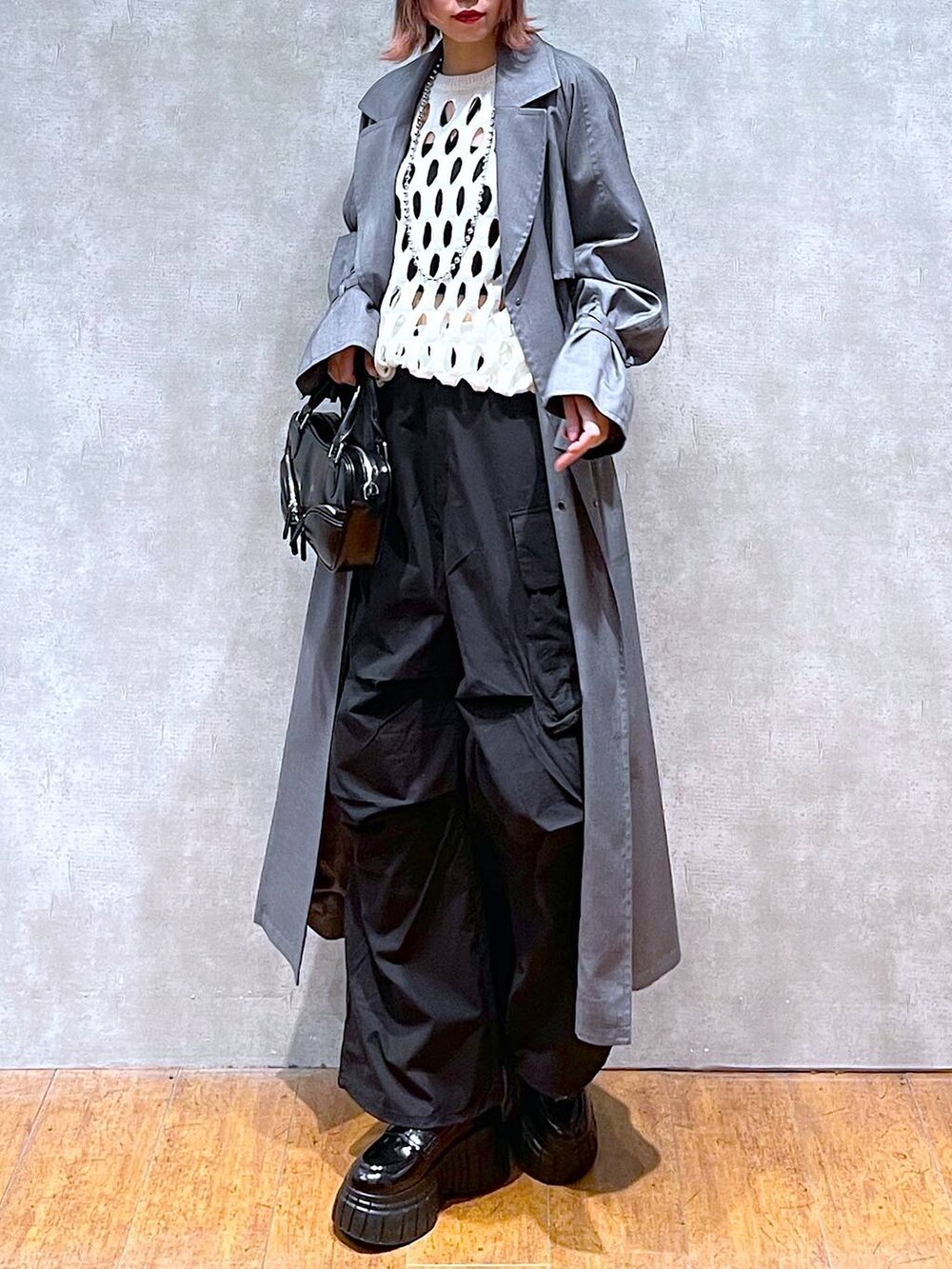 ホワイト系のニット/セーター、ブラック系のカーゴパンツ、ブラック系のキャミソールを着用したレディースの春コーディネートの2枚目の写真