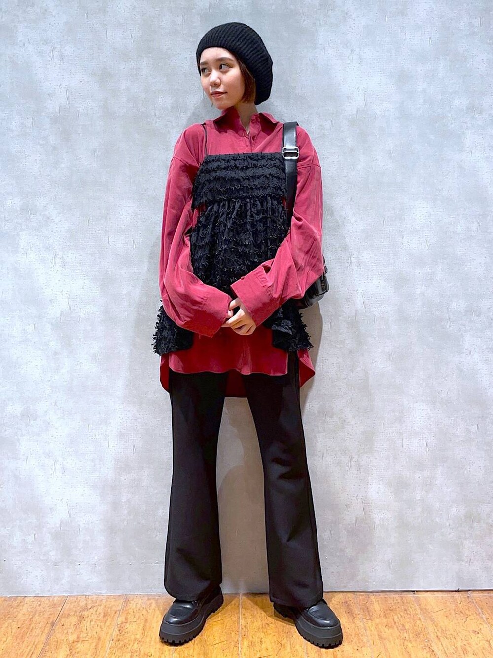 ブラック系のブーツ、ブラック系のスラックス、ブラック系のショルダーバッグを着用したレディースの秋コーディネートの4枚目の写真