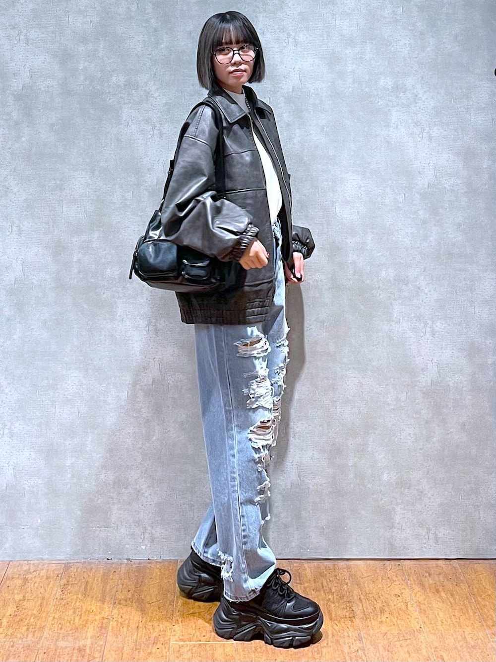 ブラック系のスニーカー、ブルー系のデニムパンツ、グレー系のブルゾンを着用したレディースの秋コーディネートの5枚目の写真