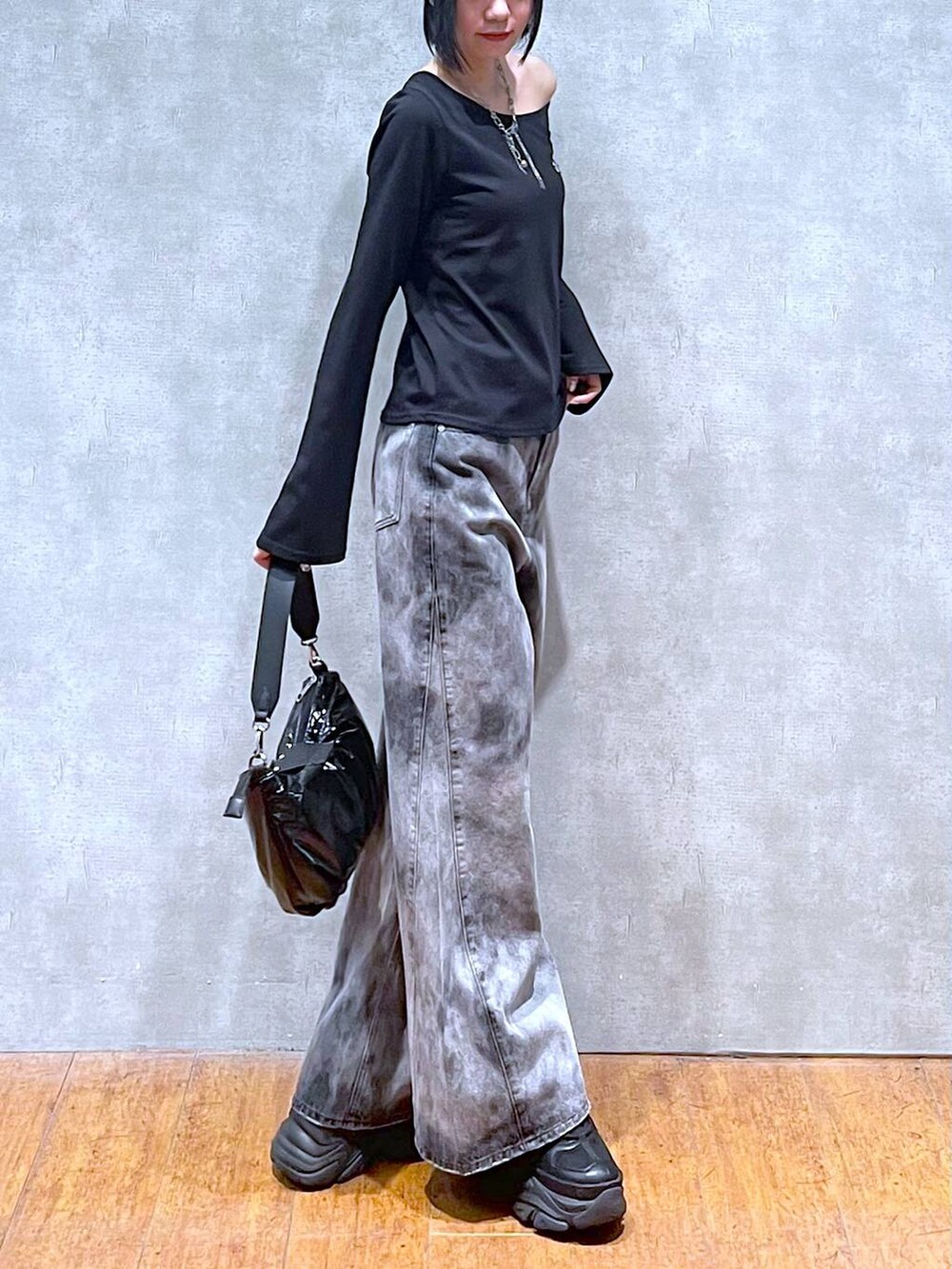 ブラック系のスニーカー、ブラック系のショルダーバッグ、ブラック系のデニムパンツを着用したレディースの夏コーディネートの4枚目の写真