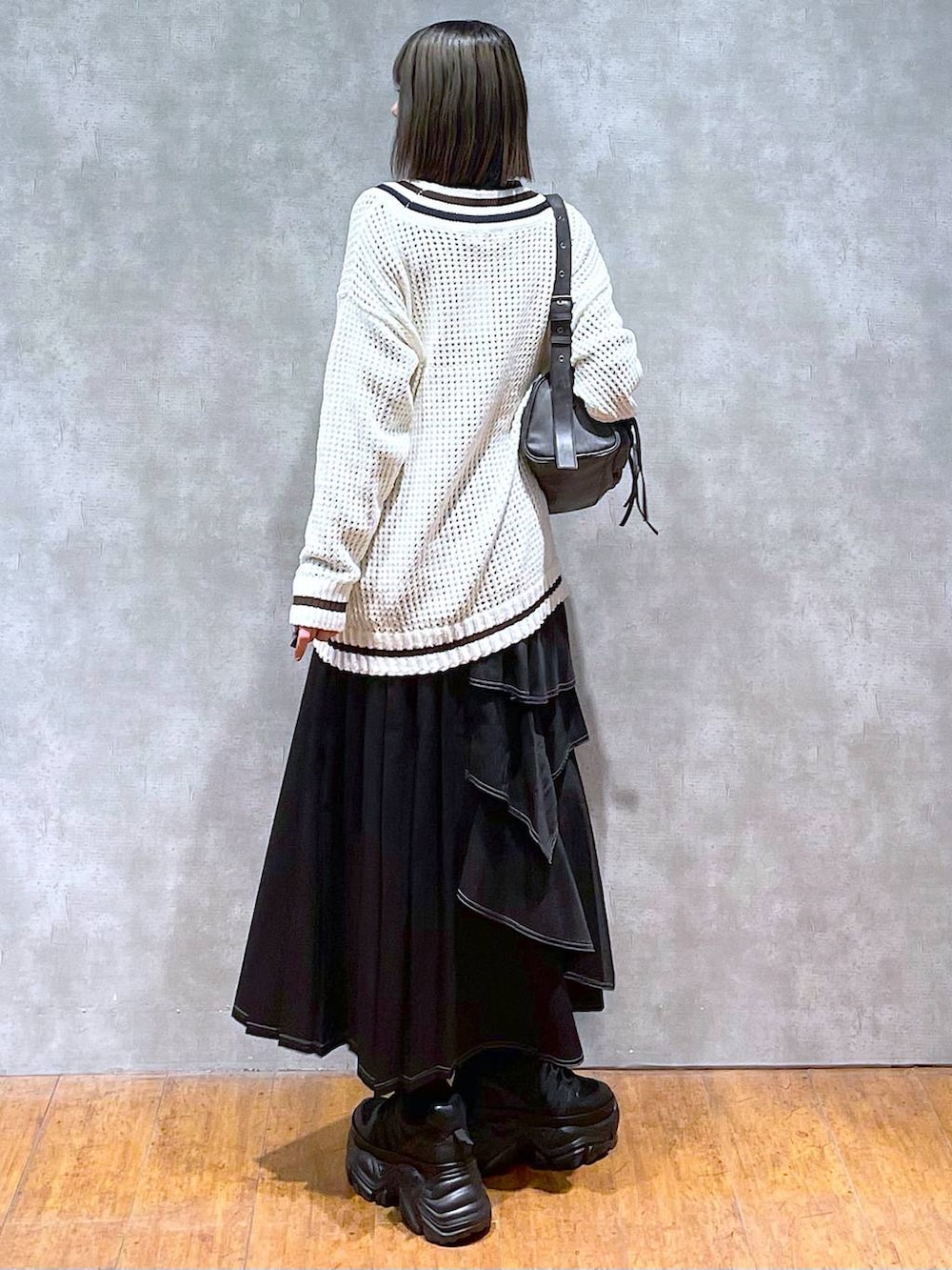 ブラック系のスニーカー、ブラック系のニット/セーター、ブラック系のショルダーバッグを着用したレディースの秋コーディネートの5枚目の写真