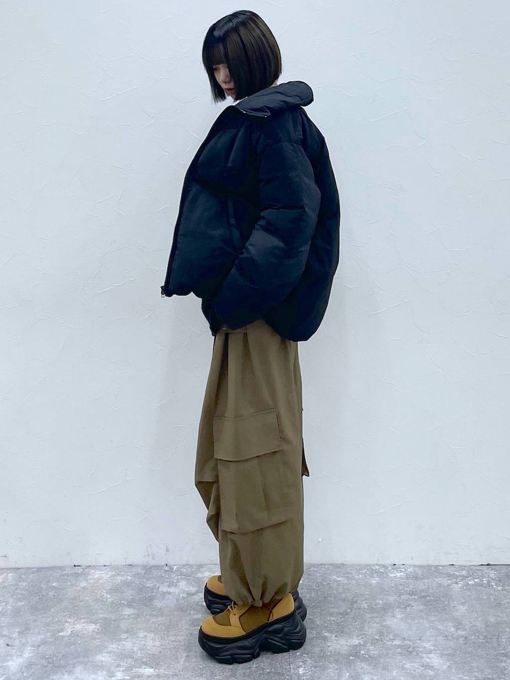 ブラウン系のブーツ、ベージュ系のカーゴパンツ、ブラック系のブルゾンを着用したレディースの秋コーディネートの5枚目の写真