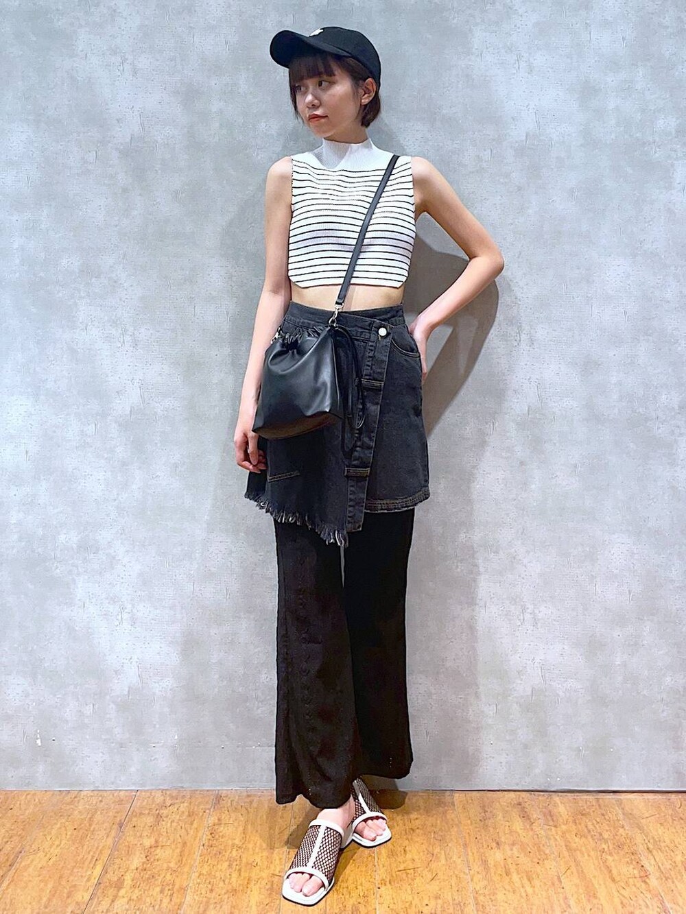 ホワイト系のサンダル、ホワイト系のTシャツ/カットソー、ブラック系のショルダーバッグを着用したレディースの夏コーディネートの2枚目の写真