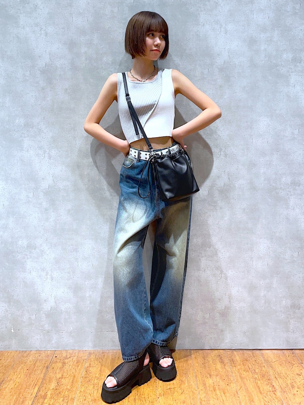 ベージュ系のタンクトップ、ブルー系のデニムパンツ、ブラック系のサンダルを着用したレディースの夏コーディネートの2枚目の写真