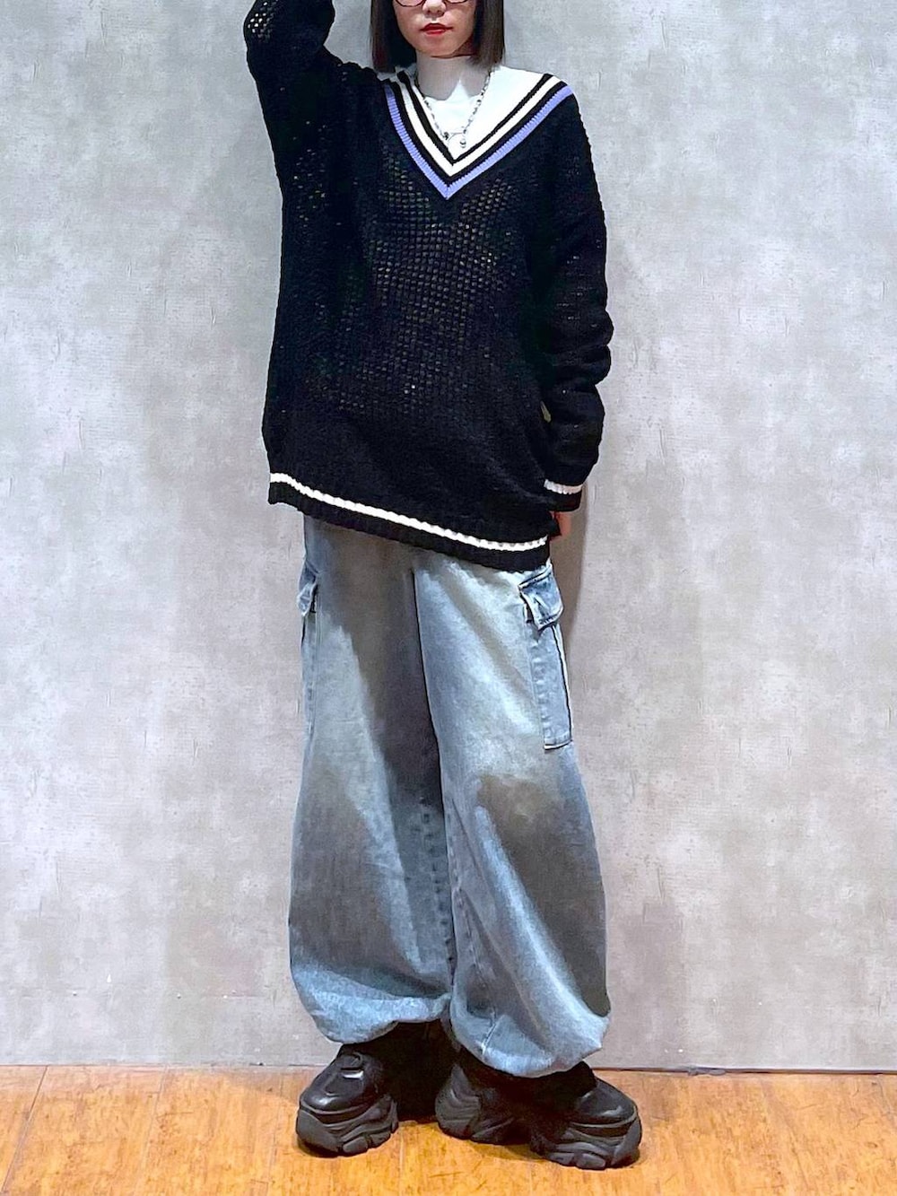 ブラック系のスニーカー、ブルー系のデニムパンツ、ブラック系のニット/セーターを着用したレディースの秋コーディネートの10枚目の写真