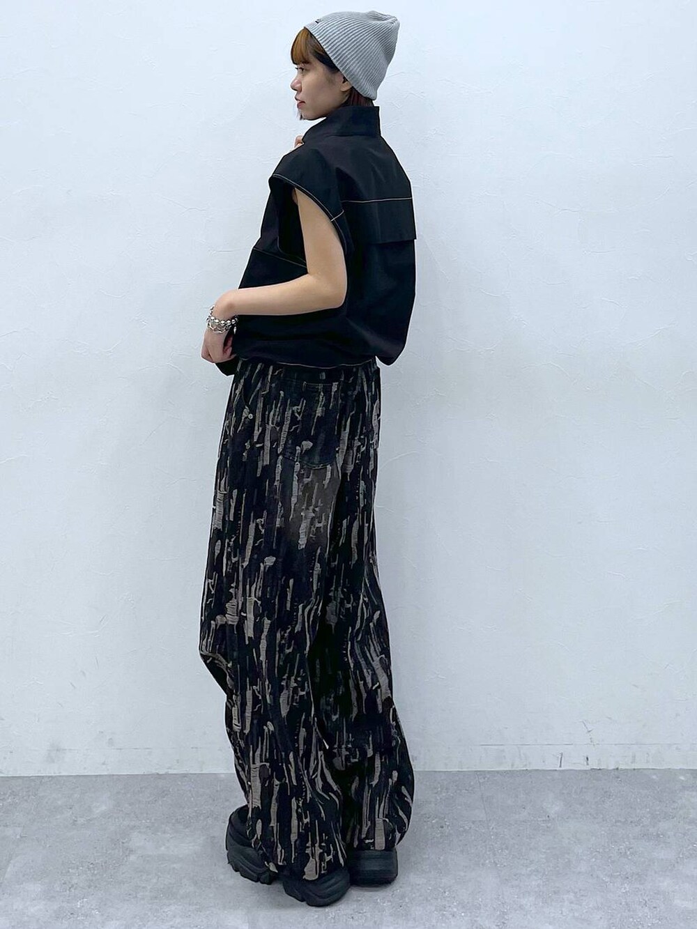 ブラック系のスニーカー、ブラック系のベスト、ブラック系のデニムパンツを着用したレディースの夏コーディネートの3枚目の写真