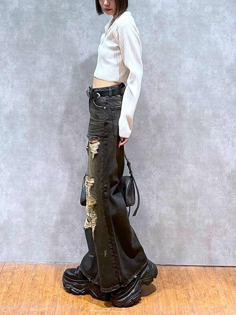 ブラック系のショルダーバッグ、ブラック系のブーツ、ブラック系のキャミソールを着用したレディースの秋コーディネートの4枚目の写真