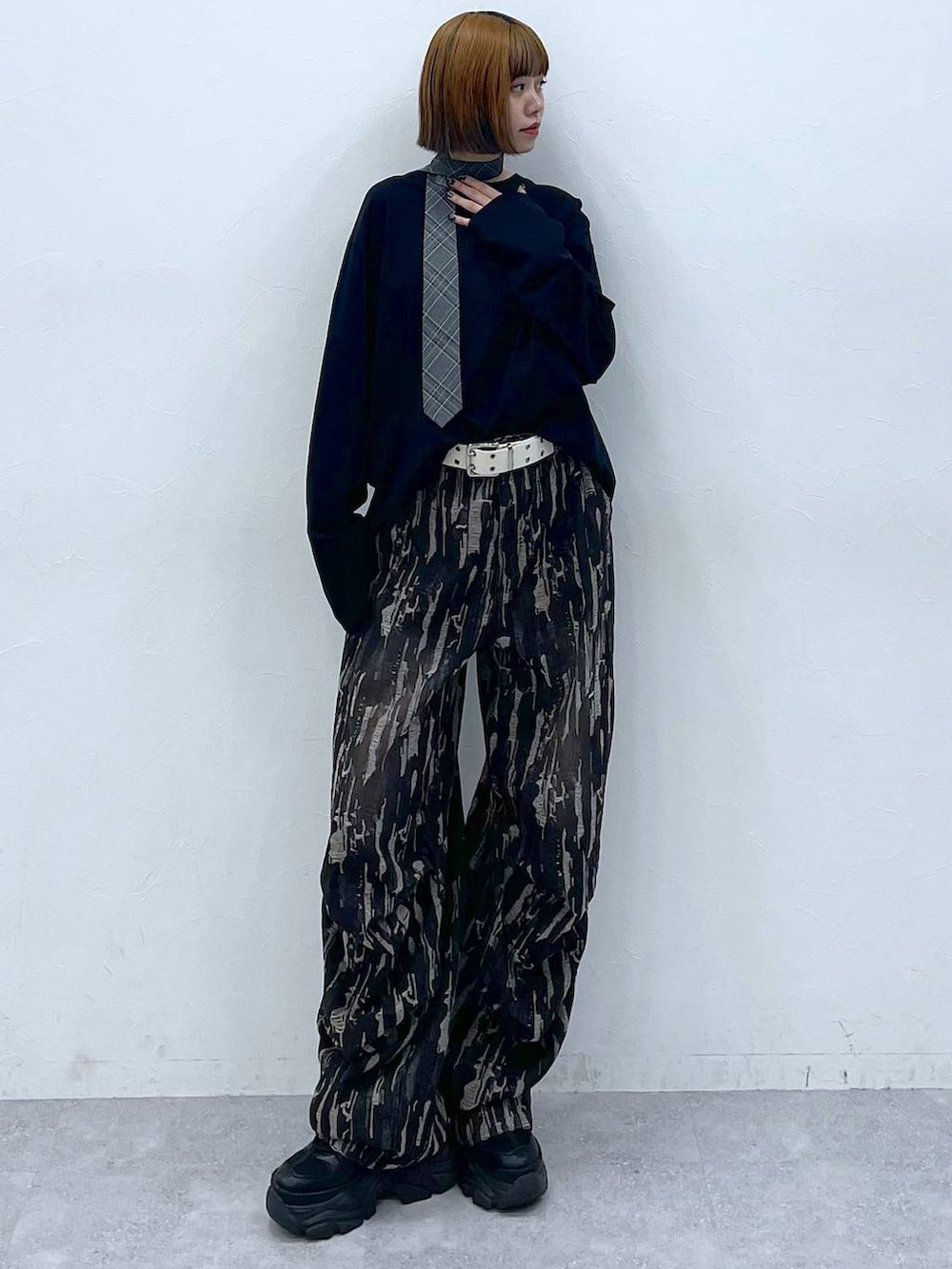 ブラック系のスニーカー、グレー系のネクタイ、ブラック系のデニムパンツを着用したレディースの夏コーディネートの2枚目の写真