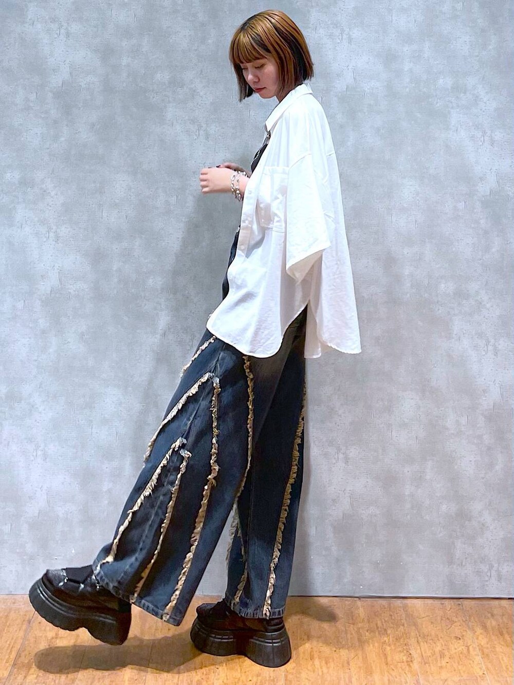 ブラック系のスニーカー、ブラック系のキャミソール、ホワイト系のシャツ/ブラウスを着用したレディースの夏コーディネートの5枚目の写真