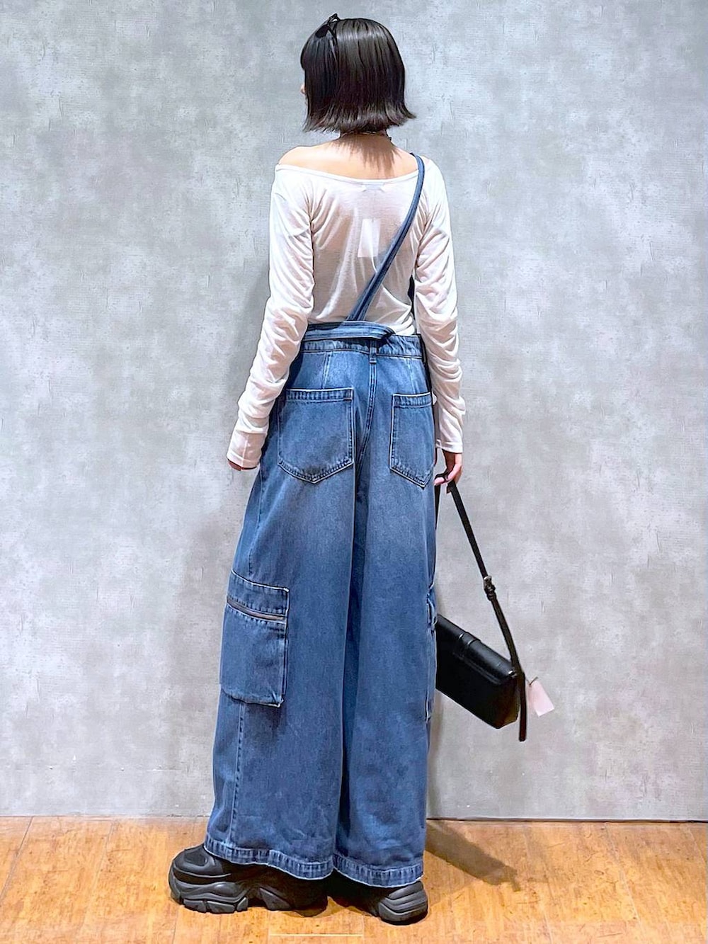 ブラック系のスニーカー、ブラック系のハンドバッグ、ブルー系のサロペット/オーバーオールを着用したレディースの夏コーディネートの3枚目の写真