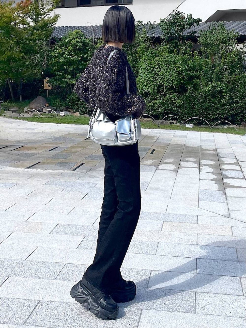 ブラック系のスニーカー、シルバー系のショルダーバッグ、ブラック系のニット/セーターを着用したレディースの秋コーディネートの8枚目の写真