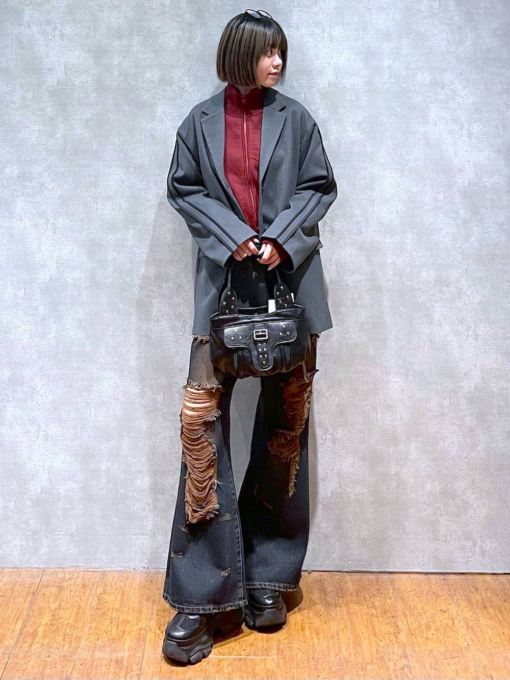 ブラック系のスニーカー、レッド系のニット/セーター、ブラック系のハンドバッグを着用したレディースの秋コーディネートの8枚目の写真