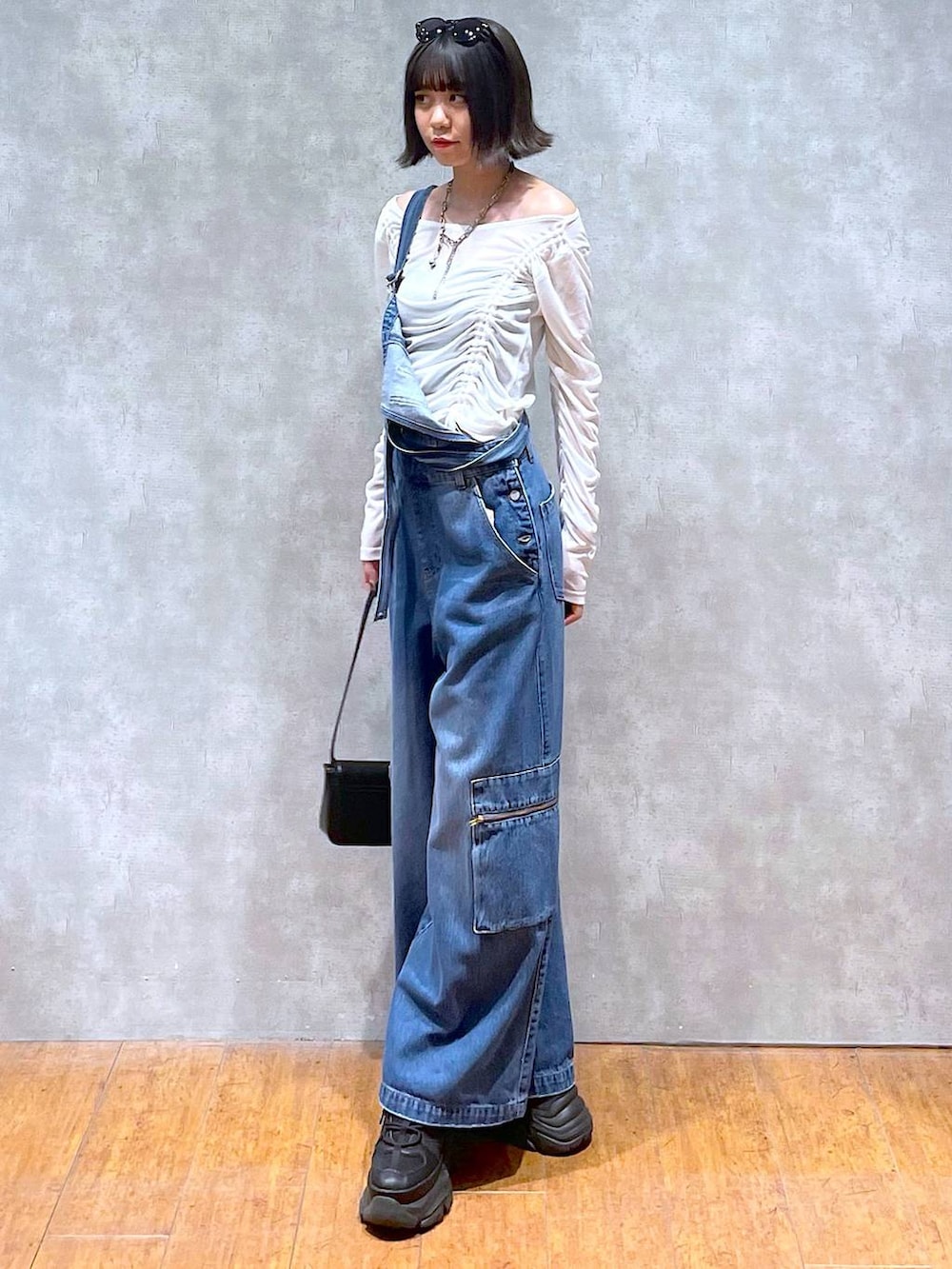 ブラック系のスニーカー、ブラック系のハンドバッグ、ブルー系のサロペット/オーバーオールを着用したレディースの夏コーディネートの5枚目の写真