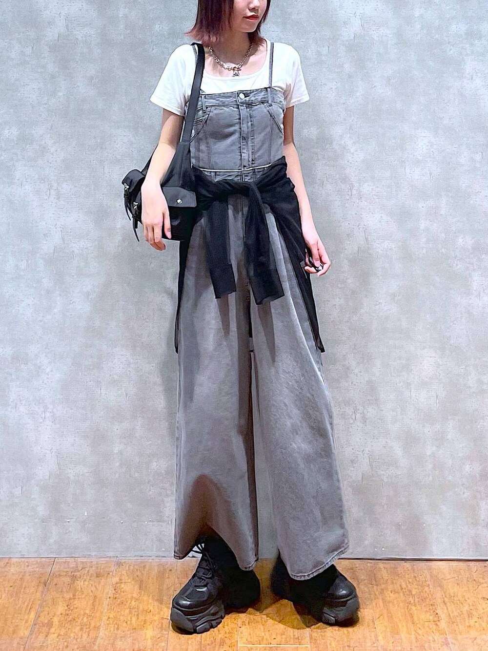 ブラック系のショルダーバッグ、ブラック系のサロペット/オーバーオール、ブラック系のスニーカーを着用したレディースの春コーディネートの2枚目の写真