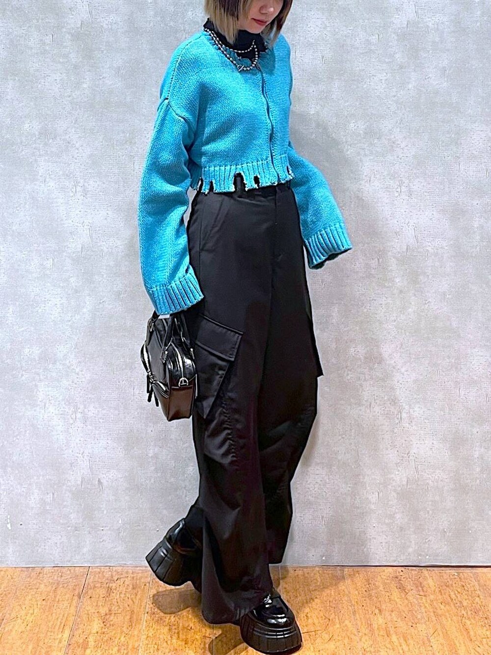 ブラック系のTシャツ/カットソー、グリーン系のニット/セーター、ブラック系のその他パンツを着用したレディースの冬コーディネートの6枚目の写真