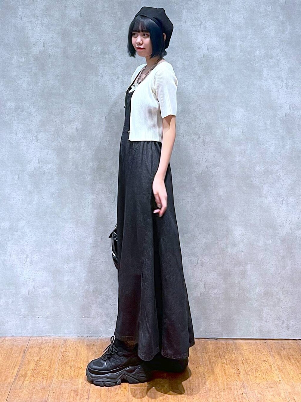 ブラック系のスニーカー、ブラック系のワンピース、ホワイト系のキャミソールを着用したレディースの夏コーディネートの3枚目の写真