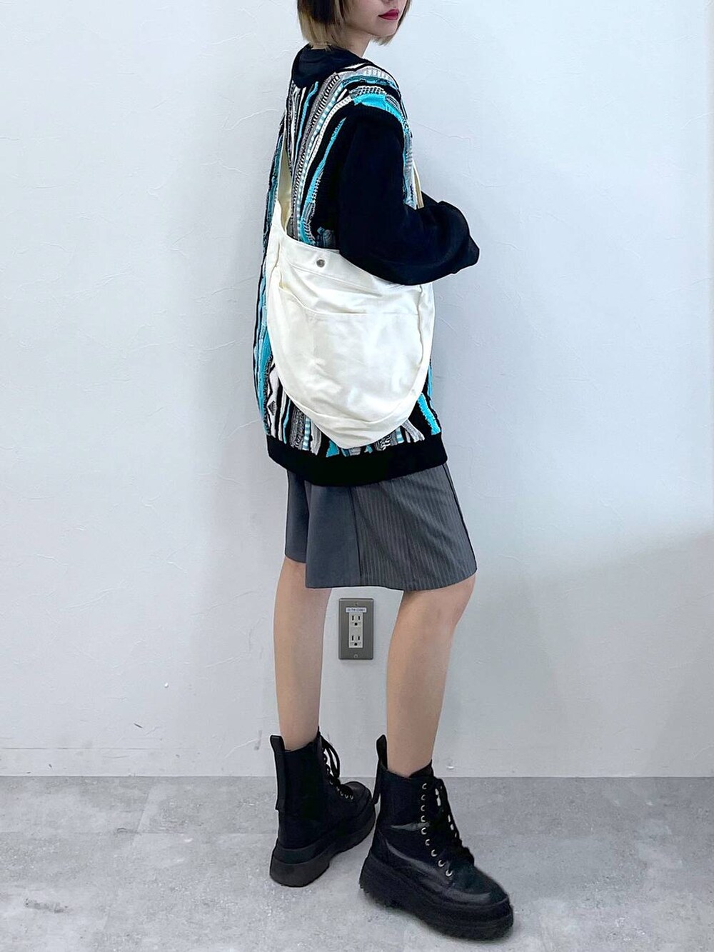 グレー系のスラックス、ブラック系のTシャツ/カットソー、ブラック系のブーツを着用したレディースの春コーディネートの3枚目の写真