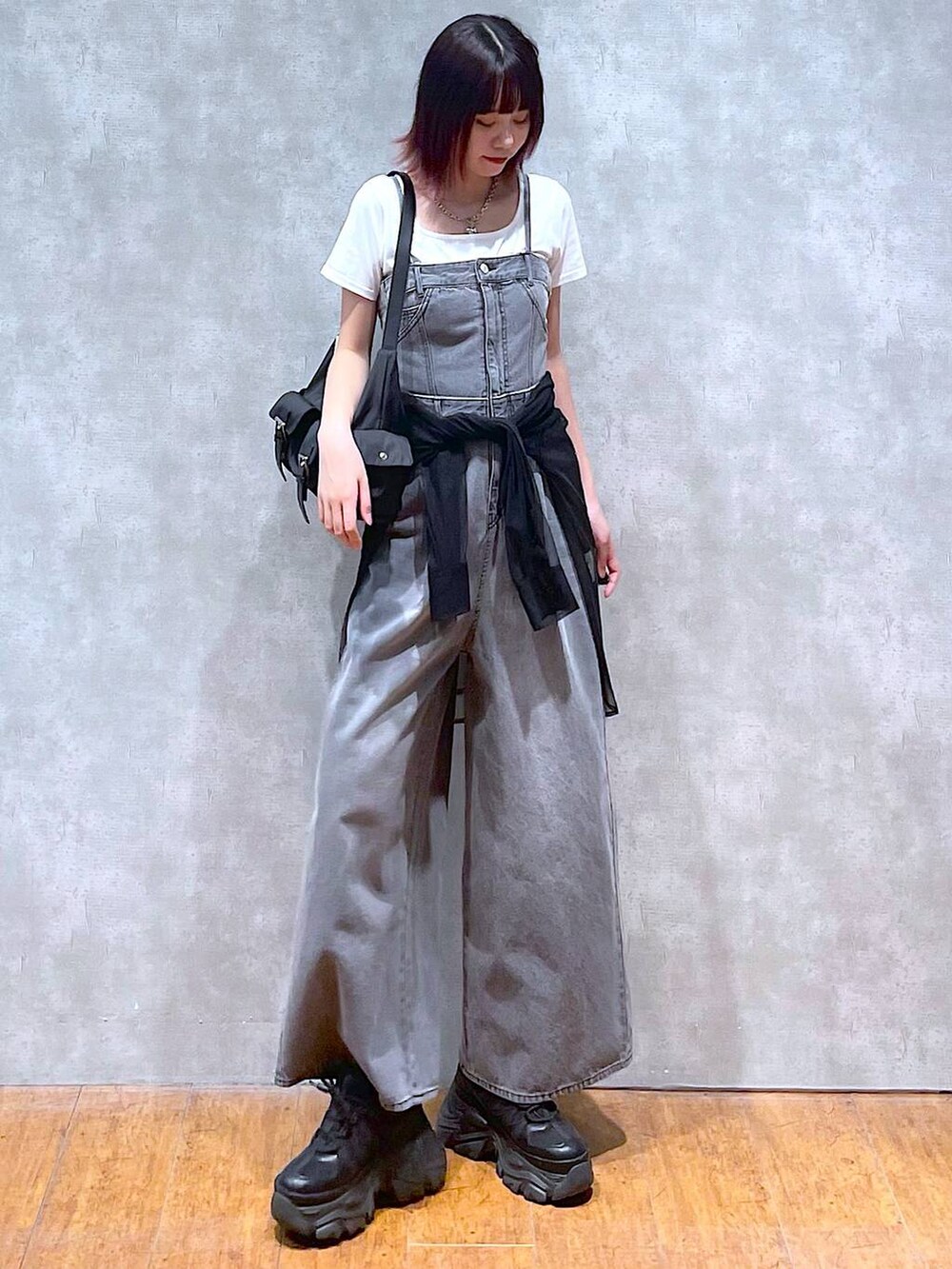 ブラック系のショルダーバッグ、ブラック系のサロペット/オーバーオール、ブラック系のスニーカーを着用したレディースの春コーディネートの4枚目の写真